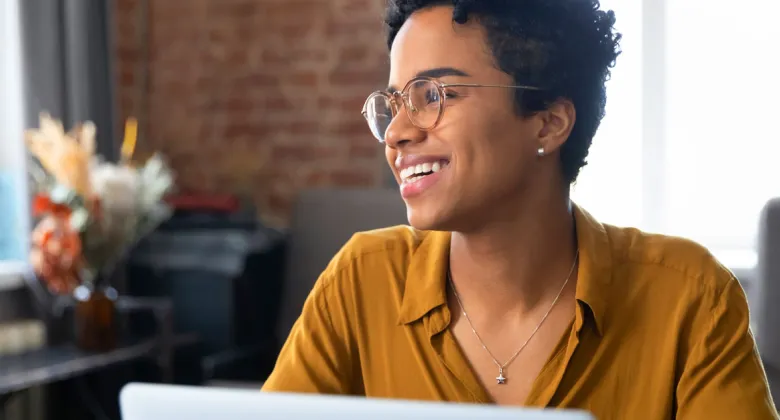A woman smiles while working on a computer