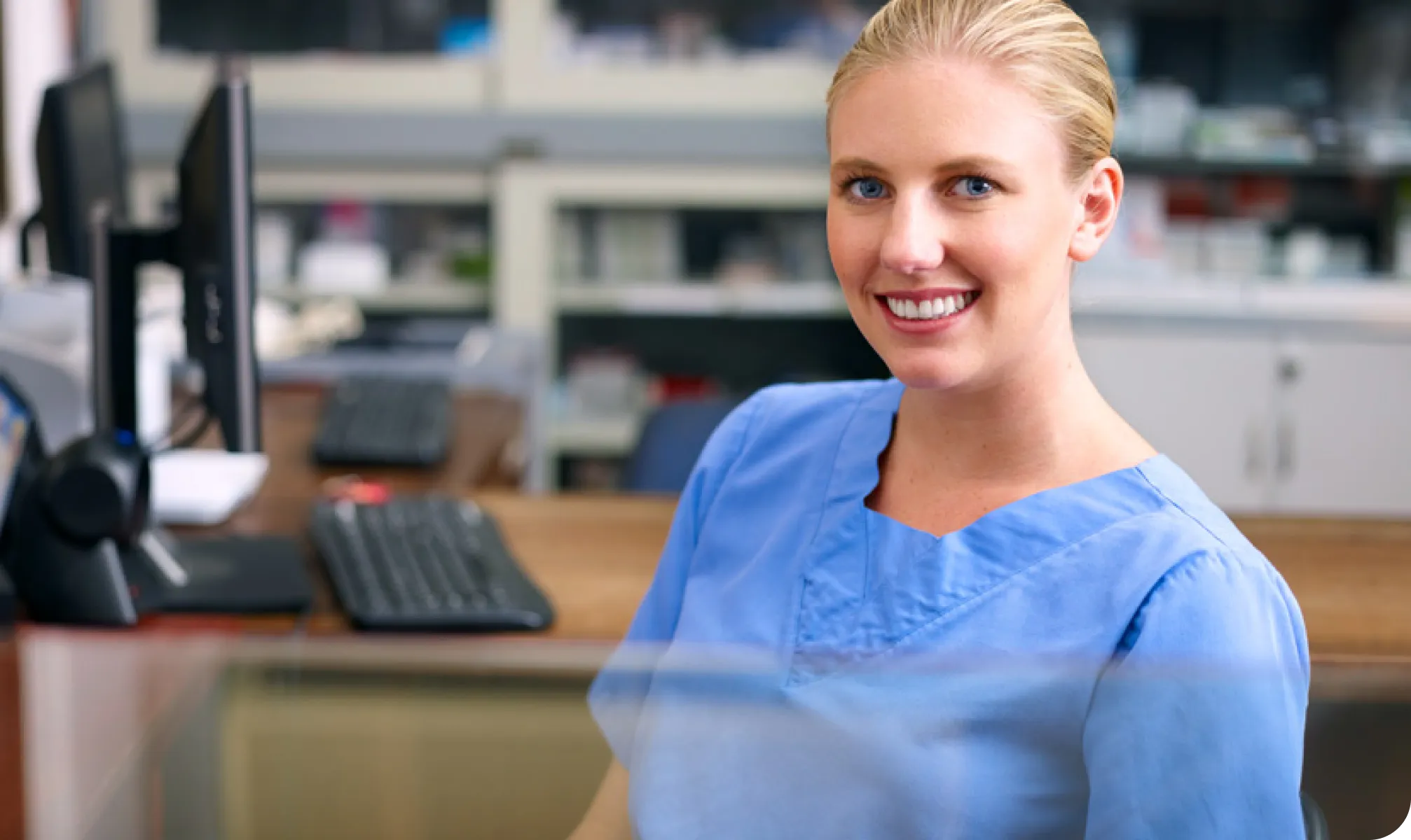 A woman wearing scrubs smiling