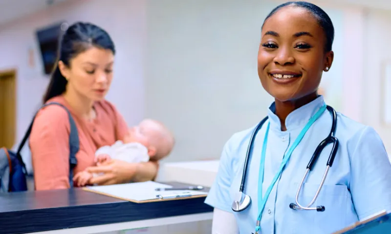A woman holding a baby and a healthcare professional in a medical setting